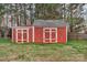 A vibrant red shed with white doors and trim provides ample storage space in the backyard at 3509 Havenwood Rd, Dallas, NC 28034