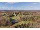 A distant aerial perspective reveals the property's extensive acreage, adorned with a pond and lush forests at 3526 Harmony Hwy, Harmony, NC 28634