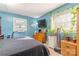 Relaxing bedroom with natural light, plants and blue accent wall, creating a tranquil atmosphere at 3526 Harmony Hwy, Harmony, NC 28634