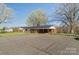 One-story brick home with large paved parking area and mature shade trees at 3526 Harmony Hwy, Harmony, NC 28634