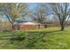 Charming one-story brick home surrounded by mature trees and a lush green lawn at 3526 Harmony Hwy, Harmony, NC 28634