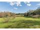 Lush green space surrounded by budding trees against a clear blue sky creates a peaceful, inviting outdoor area at 3526 Harmony Hwy, Harmony, NC 28634