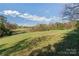 Beautiful land featuring lush green grass, mature trees, and a tranquil pond for a serene setting at 3526 Harmony Hwy, Harmony, NC 28634