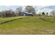 Spacious blue outbuilding situated on a grassy, gently sloping lot with mature trees at 3526 Harmony Hwy, Harmony, NC 28634