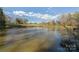 Scenic view of a tranquil pond reflecting the sky, surrounded by trees and greenery at 3526 Harmony Hwy, Harmony, NC 28634