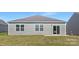 The backyard has a large lawn, grey siding, a sliding glass door and several windows at 3543 Cramer Creek Dr, Gastonia, NC 28056