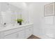 Bright bathroom with dual sinks, large mirror, white cabinets, and modern fixtures at 3543 Cramer Creek Dr, Gastonia, NC 28056