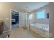 Ensuite bathroom with soaking tub, shower and doorway to main bedroom at 3613 Martele Dr, Mint Hill, NC 28227
