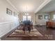Formal dining room featuring elegant wainscoting, chandelier lighting, neutral wall color, and hardwood floors at 3613 Martele Dr, Mint Hill, NC 28227