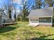 Landscaped backyard with detached garage and inviting deck at 3647 Glen Haven Sw Dr, Concord, NC 28027