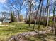 Backyard with a gentle slope, bordered with a natural rock feature and mature trees offering privacy at 3647 Glen Haven Sw Dr, Concord, NC 28027