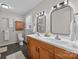 Bathroom with dual vanity, mirrors, wood cabinetry, and shower and toilet at 3647 Glen Haven Sw Dr, Concord, NC 28027
