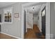 Inviting hallway featuring hardwood floors, neutral paint, and staircase with natural light at 3647 Glen Haven Sw Dr, Concord, NC 28027