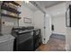 Laundry room featuring a modern washer and dryer, sink, shelving and light wood-look floors at 3647 Glen Haven Sw Dr, Concord, NC 28027