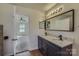Bathroom featuring a double vanity with granite countertop, dark cabinets and modern faucets at 3753 Capps Hill Dr, Charlotte, NC 28216
