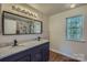 Bathroom with granite countertop vanity, modern lighting, and a view of the walk-in shower at 3753 Capps Hill Dr, Charlotte, NC 28216