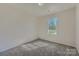 A cozy bedroom features neutral walls, carpet flooring, and a sunlit window at 3753 Capps Hill Dr, Charlotte, NC 28216
