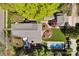 Aerial view of a home featuring a pool, manicured lawn, a garden, and a grey shingle roof at 411 Walnut St, Davidson, NC 28036