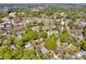 Aerial view showcasing a residential area with lush greenery and a glimpse of a lake in the distance at 411 Walnut St, Davidson, NC 28036