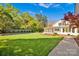 Expansive backyard with a swimming pool, lush green lawn, and landscaped garden beds near a white house at 411 Walnut St, Davidson, NC 28036