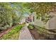Landscaped backyard featuring a gravel path, lush greenery, and a view of the main house at 411 Walnut St, Davidson, NC 28036