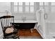 Bright bathroom with clawfoot tub, a shower, and a window with plantation shutters at 411 Walnut St, Davidson, NC 28036