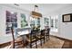Sun-drenched dining area featuring bench seating, a long wooden table and multiple windows at 411 Walnut St, Davidson, NC 28036