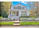 Charming two-story home featuring a cozy front porch, white picket fence and mature landscaping at 411 Walnut St, Davidson, NC 28036