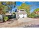 A white two-car garage with a basketball hoop and driveway, landscaped with trees and a green gate at 411 Walnut St, Davidson, NC 28036