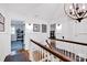 Upstairs hallway featuring hardwood floors, white wainscoting, and decorative lighting fixture at 411 Walnut St, Davidson, NC 28036