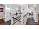 Upstairs hallway featuring hardwood floors and white wainscoting, decorative lighting fixtures at 411 Walnut St, Davidson, NC 28036
