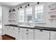 Bright kitchen with built-in sink, white cabinets, and classic black countertops at 411 Walnut St, Davidson, NC 28036