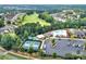 An aerial view showcasing the community pool, tennis court, and green trees at 45008 Wigeon Ln # 101, Indian Land, SC 29707