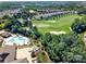 Aerial view of a golf course, pool, and clubhouse surrounded by homes and lush trees at 45008 Wigeon Ln # 101, Indian Land, SC 29707
