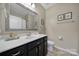 Bright bathroom with a large mirror, vanity with black cabinets, and a toilet at 45008 Wigeon Ln # 101, Indian Land, SC 29707