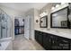 Bathroom featuring double sinks, dark cabinetry and a walk-in closet for ample storage at 45008 Wigeon Ln # 101, Indian Land, SC 29707
