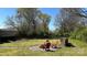 Spacious backyard with a fire pit, red Adirondack chairs, and a wood pile at 4807 Lon Parker Rd # 1, Waxhaw, NC 28173