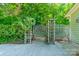 Backyard fence with wooden trellis and gate. Landscaped area with greenery and concrete path at 5232 Silchester Ln, Charlotte, NC 28215