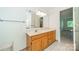 Bright bathroom featuring a large mirror, vanity with sink, and a view into the bedroom at 5232 Silchester Ln, Charlotte, NC 28215