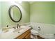 Charming bathroom with a round mirror and a light wood vanity at 5232 Silchester Ln, Charlotte, NC 28215