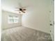 Well-lit bedroom featuring carpet, ceiling fan, and window at 5232 Silchester Ln, Charlotte, NC 28215
