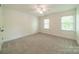 Bedroom with two windows for natural light, carpet flooring, and ceiling fan at 5232 Silchester Ln, Charlotte, NC 28215