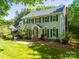 Classic two-story home with a green lawn, mature trees, and traditional design elements at 5232 Silchester Ln, Charlotte, NC 28215
