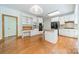 Open-concept kitchen with white cabinetry, stainless appliances, island, and desk area at 5232 Silchester Ln, Charlotte, NC 28215