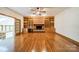 Spacious living room with hardwood floors, brick fireplace, built-in shelves, and ceiling fan at 5232 Silchester Ln, Charlotte, NC 28215
