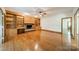Large living room with hardwood floors, brick fireplace, custom shelving, and modern ceiling fan at 5232 Silchester Ln, Charlotte, NC 28215
