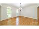 Bright, hardwood floor in room with a chandelier, windows, and white walls at 5232 Silchester Ln, Charlotte, NC 28215