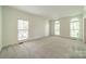 Bright living room featuring neutral carpet, crown molding, and windows letting in lots of natural light at 5232 Silchester Ln, Charlotte, NC 28215