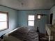 Bedroom featuring two windows, blue walls, and an unfinished ceiling at 526 Peaceful Leaf Ln, Kings Mountain, NC 28086