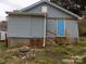 Exterior view shows light blue siding and a new-looking back door with steps at 526 Peaceful Leaf Ln, Kings Mountain, NC 28086